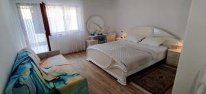 a bedroom with a large white bed and a couch at More in Crikvenica
