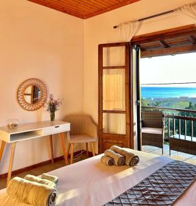 a bedroom with a bed and a view of the ocean at Golden View Apartments in Arillas