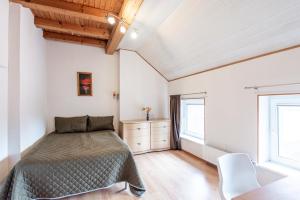 a bedroom with a bed and two windows at Apartamentai pas Reginą in Palanga
