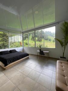 a bedroom with a bed and a table and windows at El Rancho de Salento in Salento