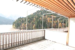 balcone con vista su un lago e sugli alberi di Albergo Diffuso Sauris in La Maina a Sauris