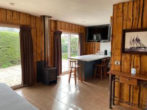a kitchen with wooden walls and a kitchen with a island at Acogedora casa cerca del Bosque El Canelo in Algarrobo
