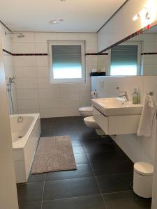 a bathroom with two sinks and a tub and a toilet at Modernes Ferienhaus mit 2 Balkonen, Terrasse und Garten ! in Bochum +27 photos