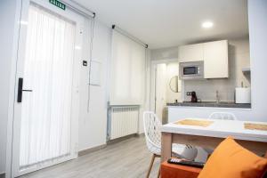 eine kleine Küche mit einem Tisch und einer Küche sidx sidx sidx in der Unterkunft Pregonero Urban Suites - Naranja in Soria