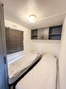 two beds in a small room with a window at Dulczetto Camp in Jastarnia +4 photos