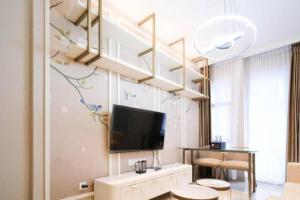 a living room with a tv on a wall at Amazing 2BR Benson Apartment in Pakuwon mall in Surabaya +5 photos