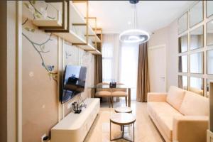 a living room with a couch and a tv at Amazing 2BR Benson Apartment in Pakuwon mall in Surabaya