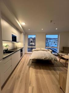 ein großes Schlafzimmer mit einem Bett und einer Küche in der Unterkunft New exclusive appartment with seaview in Tromsø