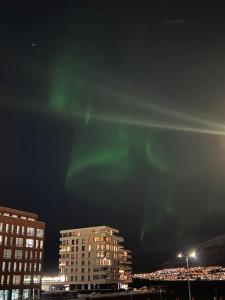 ein Bild der Nordlichter am Himmel über Gebäuden in der Unterkunft New exclusive appartment with seaview in Tromsø