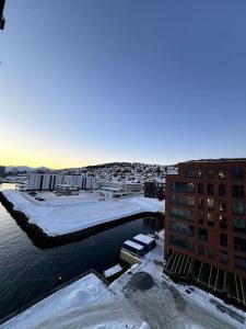 eine Stadt mit Schnee auf dem Wasser und Gebäuden in der Unterkunft New exclusive appartment with seaview in Tromsø