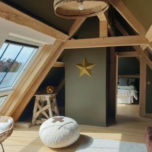 a attic room with a star on the wall at Par Hasard ou pas in Saint-Martin-aux-Chartrains