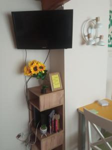 a flat screen tv hanging on a wall with a table at ArtCenterApartment in Novi Sad