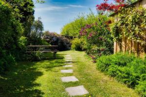 a walkway with a bench in a garden at Headgate Farm Camp Site - Pitches Only - Bring your own tent or van in South Molton