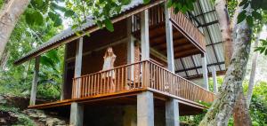 a woman standing on the balcony of a tree house at Eco Breeze - Unawatuna in Galle