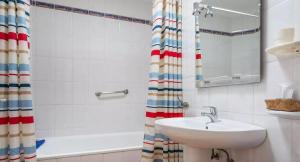 a bathroom with a sink and a shower curtain at El sombrerito 5 in Caleta de Sebo