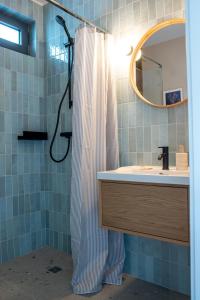 a bathroom with a shower curtain and a sink at Nadmorska Otulina - Nowoczesne dwupoziomowe domki nad morzem z dużym ogrodem in Ustka +62 photos