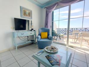 a living room with a blue chair and a table at Rocas del Mar 408 in Costa Del Silencio