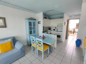 a living room with a couch and a table and chairs at Rocas del Mar 408 in Costa Del Silencio