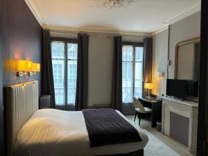 a hotel room with a bed and a desk at Hotel Le Jacquemart in Dijon