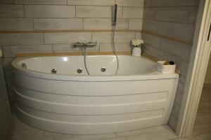 a white bath tub in a bathroom with tiles at casa vacanze la mammola in San Giorgio a Cremano +18 photos