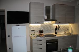 a kitchen with a white refrigerator and a sink at casa vacanze la mammola in San Giorgio a Cremano