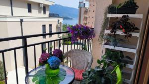 a table and chairs on a balcony with flowers at Centre Budva Blue in Budva