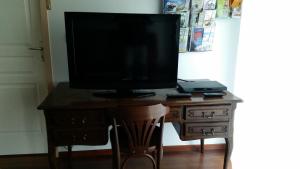 telewizor siedzący na drewnianym biurku w obiekcie Four À Pain w mieście Louer