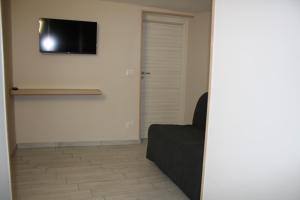 a living room with a couch and a television on the wall at casa vacanze la mammola in San Giorgio a Cremano