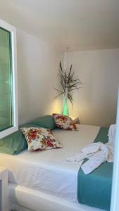 a bed with pillows and a vase on top of it at Rida Village Ksamil Island in Ksamil