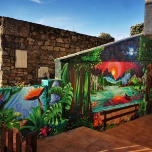 a mural on the side of a wall with flowers and plants at Apartamento Mar de Fora in Finisterre