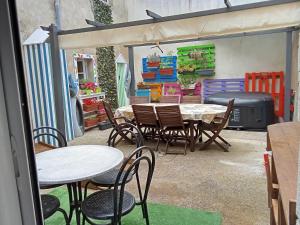 a patio with tables and chairs and a grill at Les 3B in Le Croisic