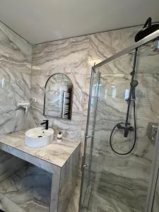 a bathroom with a sink and a shower at Home Simoni in Ploieşti