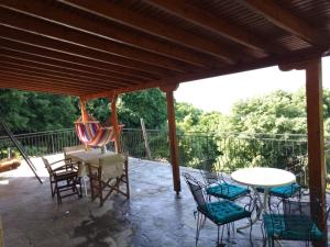 eine Terrasse mit Tisch, Stühlen und einer Hängematte in der Unterkunft Με Θεα!! in Stomio