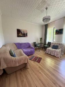 a living room with a purple couch and a table at Guest house Me and grandfather-მე და პაპა in Dedoplis Tskaro