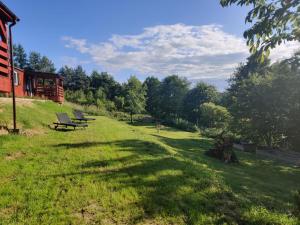 a group of benches sitting on top of a grass field at Domus Mare Tiny House 2 in Wisełka