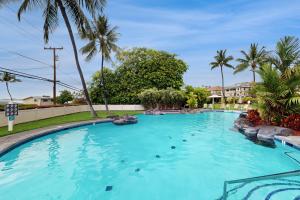 a swimming pool in a resort with palm trees at Ali'i Cove Y1 in Kailua-Kona