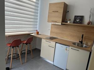 a kitchen with a counter and two stools and a sink at Apartmani Vivami in Budva +36 photos