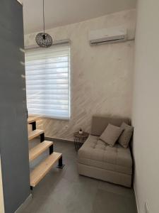 a living room with a couch and a window at Apartmani Vivami in Budva