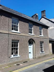 un edificio in mattoni con porta bianca e finestre di 2 bed period cottage sleeps 4 in central Crickhowell a Crickhowell