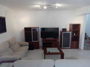 a living room with a couch and a flat screen tv at House Moledo sea view in Moledo