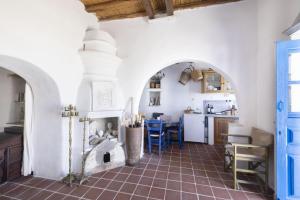 a kitchen with a stone fireplace in a house at Daphnisthe artist's house in Mamádhos