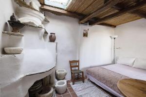 a bedroom with a bed and a table and a fireplace at Daphnisthe artist's house in Mamádhos