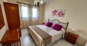 - une chambre avec un lit doté d'oreillers violets dans l'établissement El sombrerito 4, à Caleta de Sebo