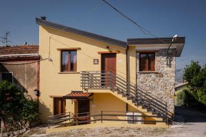 a yellow house with a staircase on it at Agriturismo e B&B Selvanera in Postiglione