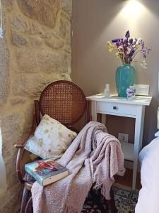 a bedroom with a chair with a table and a book at Maravillosa casa con vistas al mar in Baiona +38 photos
