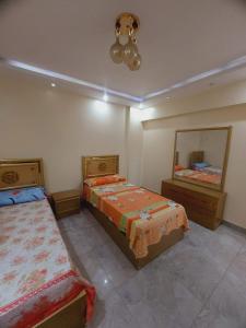 a bedroom with two beds and a mirror at Aqaba Air Inn in Aqaba