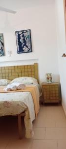 1 Schlafzimmer mit 2 Betten und einem Kopfteil aus Holz in der Unterkunft Farfalla in Vila do Maio