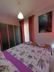 1 dormitorio con 1 cama con edredón blanco y morado en PineParkView Apartment en Alejandrópolis