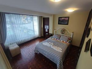 a bedroom with a bed and a large window at MATRIMONIAL TURI centro de la ciudad, garaje in Baños