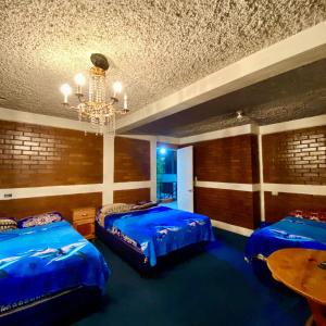 グアテマラシティにあるHotel el Mesón, Guatemalaのベッド2台とシャンデリアのある寝室